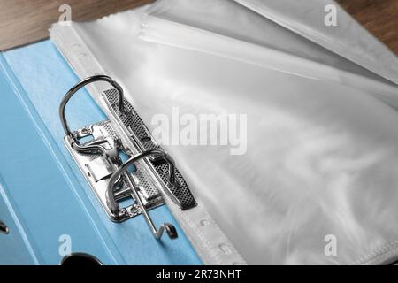 File folder with punched pockets on wooden table, closeup Stock Photo