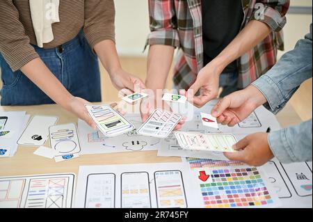A close-up image of a team of professional apps developers is in the meeting, discussing, brainstorming, and reviewing a new prototype together. tech Stock Photo