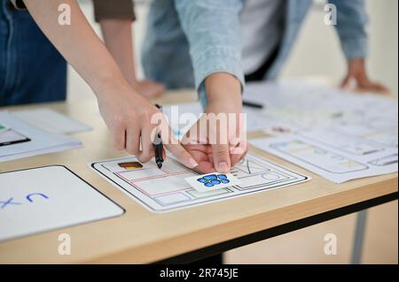 A close-up image of professional app developers brainstorming, discussing work, and working on a new app prototype in the meeting together. UI, UX, te Stock Photo