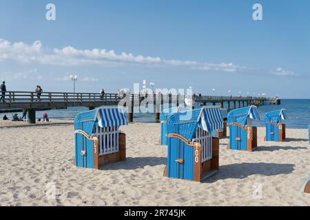 Beach chairs on the beach of Kühlungsborn on the German Baltic Sea coast. In the background the pier. Stock Photo