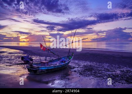 Thai Fishing boat at sunrise and low tide. Ao Noi beach, Prachuap Khiri Khan District. Thailand. Stock Photo