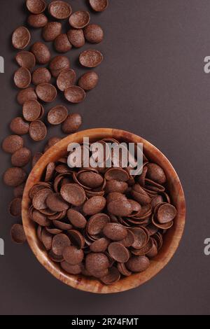 Directly above view of chocolate glazed shells on dark brown background. Space for text Stock Photo