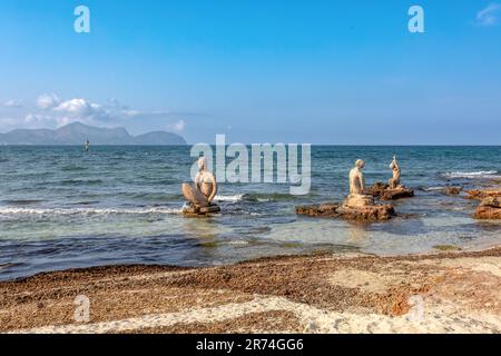 Group of sculptures, statues of people on beach in Can Picafort. Clear turquoise yeas and blue sky. Can Picafort, Balearic Islands Mallorca Spain. Tra Stock Photo