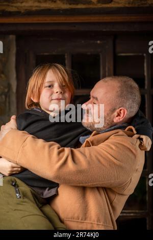 A man embraces his young son. Father's Day, the long-awaited meeting. A middle-aged man and a nine-year-old boy. Stock Photo