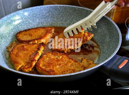 Fried pork steak in frying pan Stock Photo