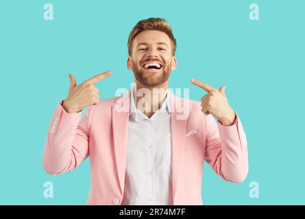 Young handsome man pointing at himself with index finger smiling positive and cheerful at camera. Stock Photo
