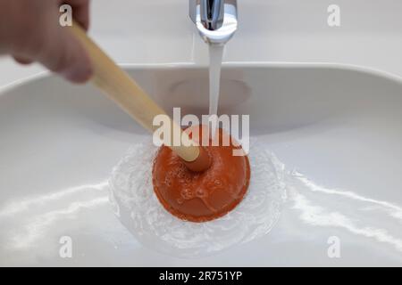 Plumber's drain cleaner tool. Rubber suction cup with wooden handle Stock  Photo - Alamy