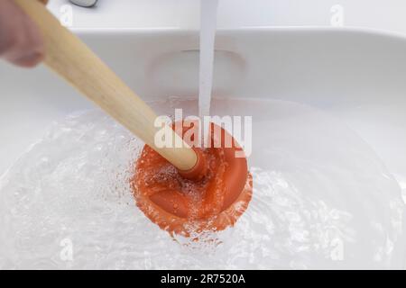 https://l450v.alamy.com/450v/2r7520a/sink-detail-clogged-drain-unclogging-with-the-plunger-2r7520a.jpg