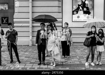 A Just Married Couple Wait To Cross The Street, Kowloon, Hong Kong, China. Stock Photo