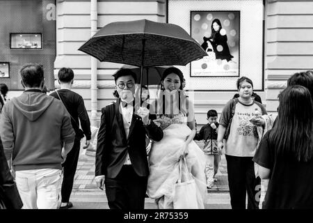 A Just Married Couple Crossing A Street In Kowloon, Hong Kong, China. Stock Photo