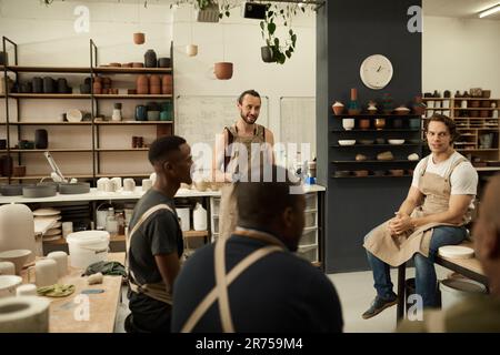 Smiling workers meeting together in a ceramics studio Stock Photo