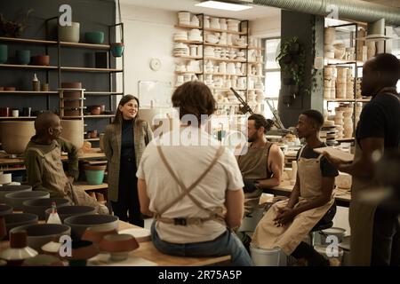 Smiling manager meeting with workers in a ceramics studio Stock Photo