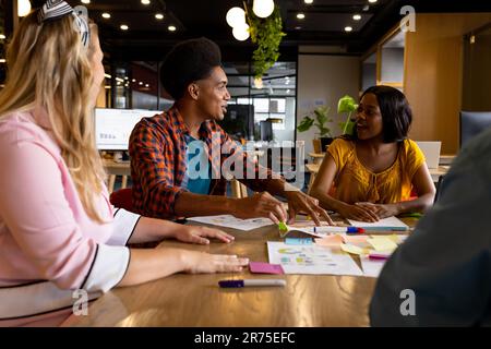 Diverse creative colleagues in discussion brainstorming using tablet and notes in office Stock Photo