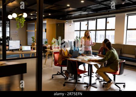 Diverse creative colleagues in discussion brainstorming at table in office Stock Photo