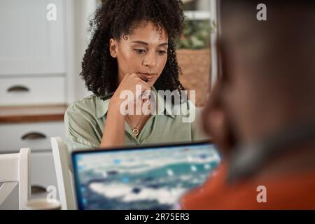 Multiracial couple using laptops while working remotely from home Stock Photo
