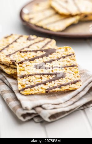 Puffed corn crackers chocolate covered on the white table. Stock Photo