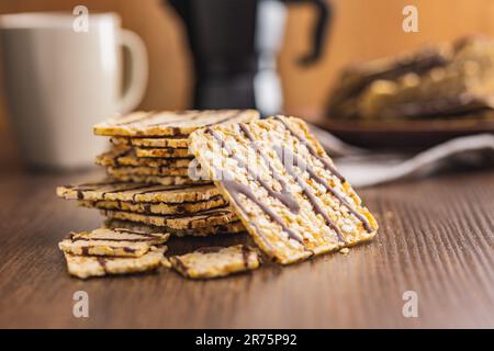 Puffed corn crackers chocolate covered on the wooden table. Stock Photo