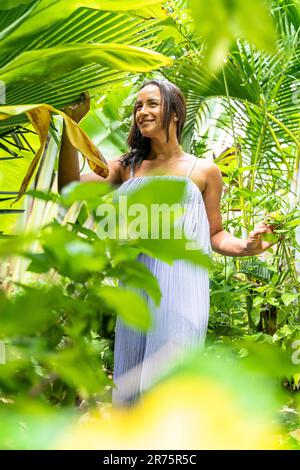 North America, Caribbean, Greater Antilles, Hispaniola Island, Dominican Republic, Sama Province, Sama Peninsula, Las Galeras, Pretty Latina in a Green Tropical Garden Stock Photo