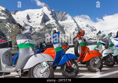 Vespa Alp Days, row of Vespas on the Kaiser-Franz-Josefs-Höhe, Großglockner, blue sky Stock Photo