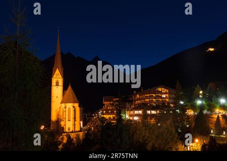 Parish church St.Vinzenz and mountain village Heiligenblut am Großglockner, at night, illuminated, Stock Photo