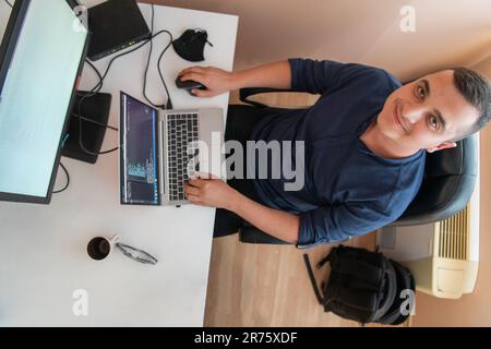 Top view of programmer diligently testing smartphone applications while sitting in their office. Stock Photo