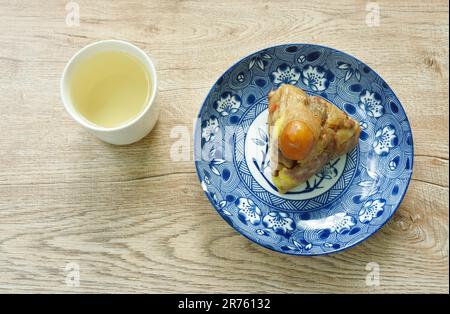 sticky rice steam with pork and salt egg of Chinese Duanwu festival on plate couple hot tea cup Stock Photo