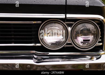 Izmir, Turkey - June 3, 2023: Close-up of the headlight on a black Chevrolet Chevelle SS covered in raindrops Stock Photo