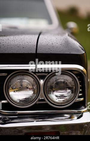 Izmir, Turkey - June 3, 2023: Close-up of the headlight on a black Chevrolet Chevelle SS covered in raindrops Stock Photo