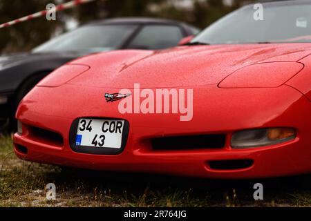 Izmir, Turkey - June 3, 2023: Close-up of the hood of a red 2000 Chevrolet Corvette with raindrops, the retractable headlights are closed Stock Photo