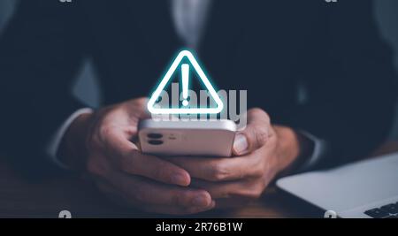 Error and maintenance alert. Businessman using computer laptop with triangle caution warning sing for notification error and maintenance concept. Stock Photo