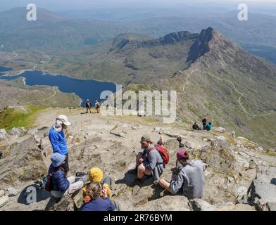 Climbers enjoying fine views and a welcome break at the summit of Snowdon Yr Wyddfa in the Eryri National Park North Wales UK Stock Photo