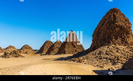 the nubian pyramids of the black pharoahs of the napata kingdom of sudan are lined up on a ridge weatherbeaten and crumbling into the desert Stock Photo