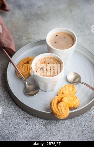 Cup of coffee with milk and biscuits on the plate served on the concrete table Stock Photo