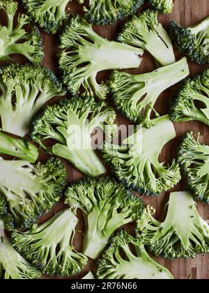 From above green broccoli stems placed on wooden background preparing to cook Stock Photo