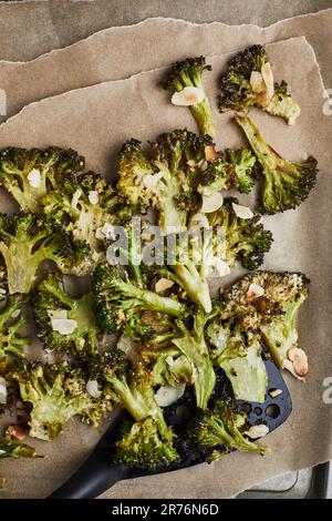 From above baked cooked green broccoli stems with cheese and pepper placed on wooden background Stock Photo