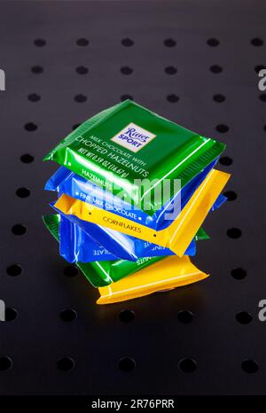 Ho Chi Minh City, Vietnam - June 13, 2023: Stack of mini chocolate bars of various flavors with Ritter Sport logo, isolated on black. A lot of candy o Stock Photo