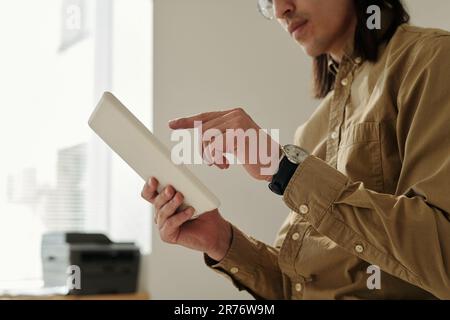 Hand of young male manager pointing at tablet screen during presentation or while analyzing online financial data Stock Photo