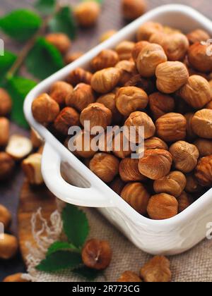 Peeled hazelnut kernels in a bowl. Still life of fresh nuts from above. Promotional card for the sale of nuts in an online store or on trading floors. Useful herbal product for a healthy diet. Stock Photo