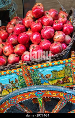 Sicilian cart decorated with stories of the heroes of Taormina loaded with red pomegranates. Taormina, Messina province, Sicily, Italy, Europe Stock Photo