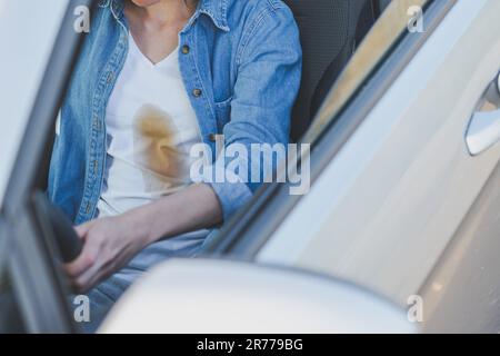 Coffee stain. Unrecognizable girl spilling coffee or tea on herself. Spoiled clothes. Concept of cleaning stains on clothes Stock Photo