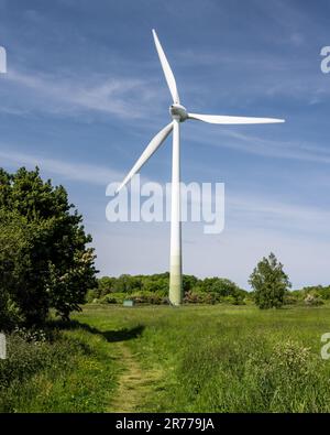 A wind turbine stands against a blue sky at Sharpness Docks in Gloucestershire, England. Stock Photo