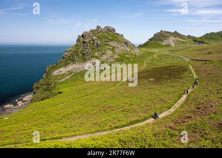 Hikers walk on the South West Coast Path at the Valley of Rocks near Lynton in North Devon, England. Stock Photo