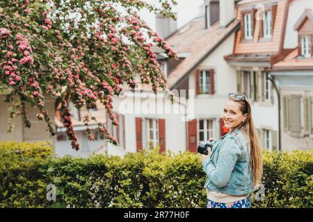 Young beautiful woman enjoying spring in the city, fashion girl wearing denim jacket. Image taken in Lausanne, Switzerland Stock Photo