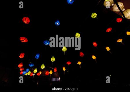 Colourful lights. Hanging lanterns in the dark night background Stock Photo