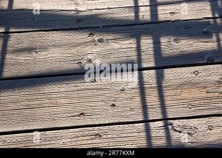 Intersecting lines, shadows on rough textured boardwalk, abstract desin Stock Photo