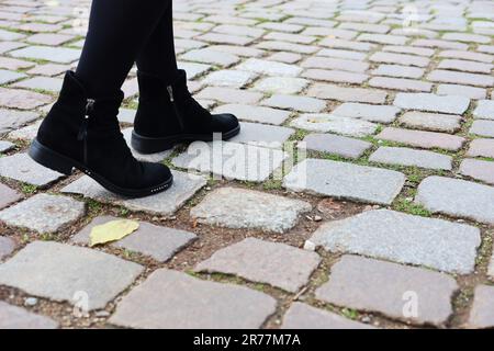Close-up of a young woman's legs on a paved street in the old town. Journey. Tourism Stock Photo