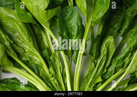 Fresh green spinach leaves close-up on a white background. A bunch of spinach as a background, the concept of healthy products. Stock Photo