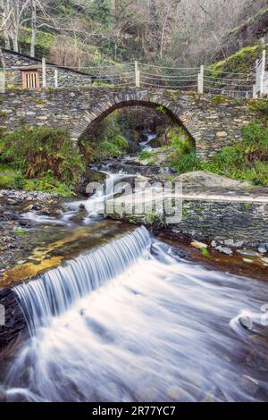 View of waterfall and stone bridge over a stream on the river beach of the historic village of Piódão in Portugal. Stock Photo
