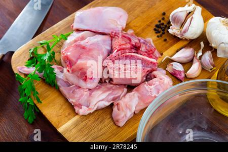 Delicious cutting rabbit meat with spices and herbs on kitchen board Stock Photo