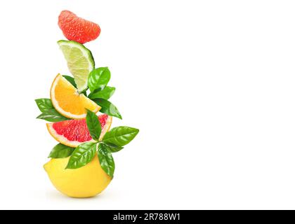Stack of different fresh citrus fruits with green leaves on white background Stock Photo